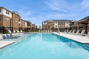 A large swimming pool in front of apartment buildings.